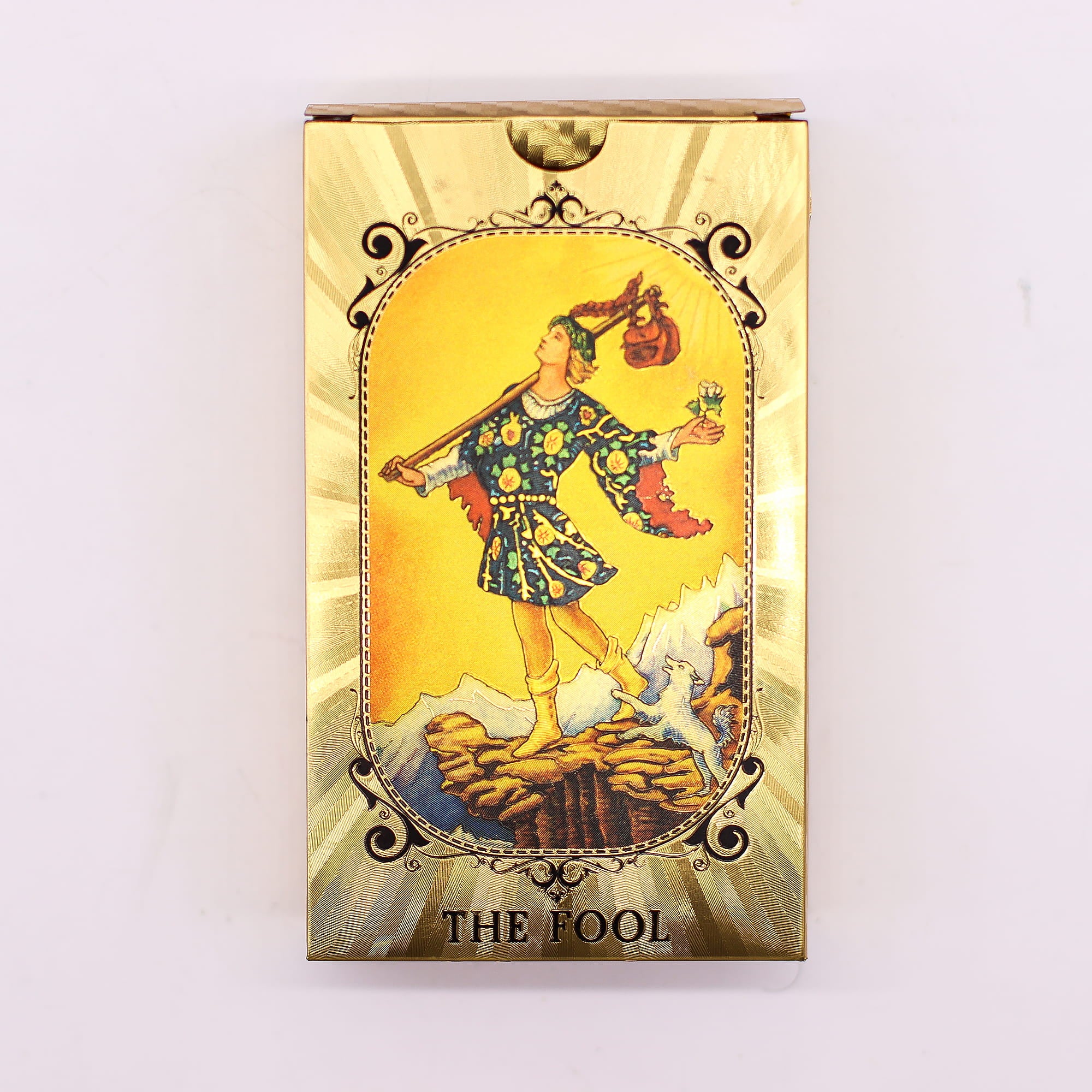 Přední strana zlaté krabičky Gold Foil Tarot s kartou The Fool – zlatá fólie s ornamentálním rámem