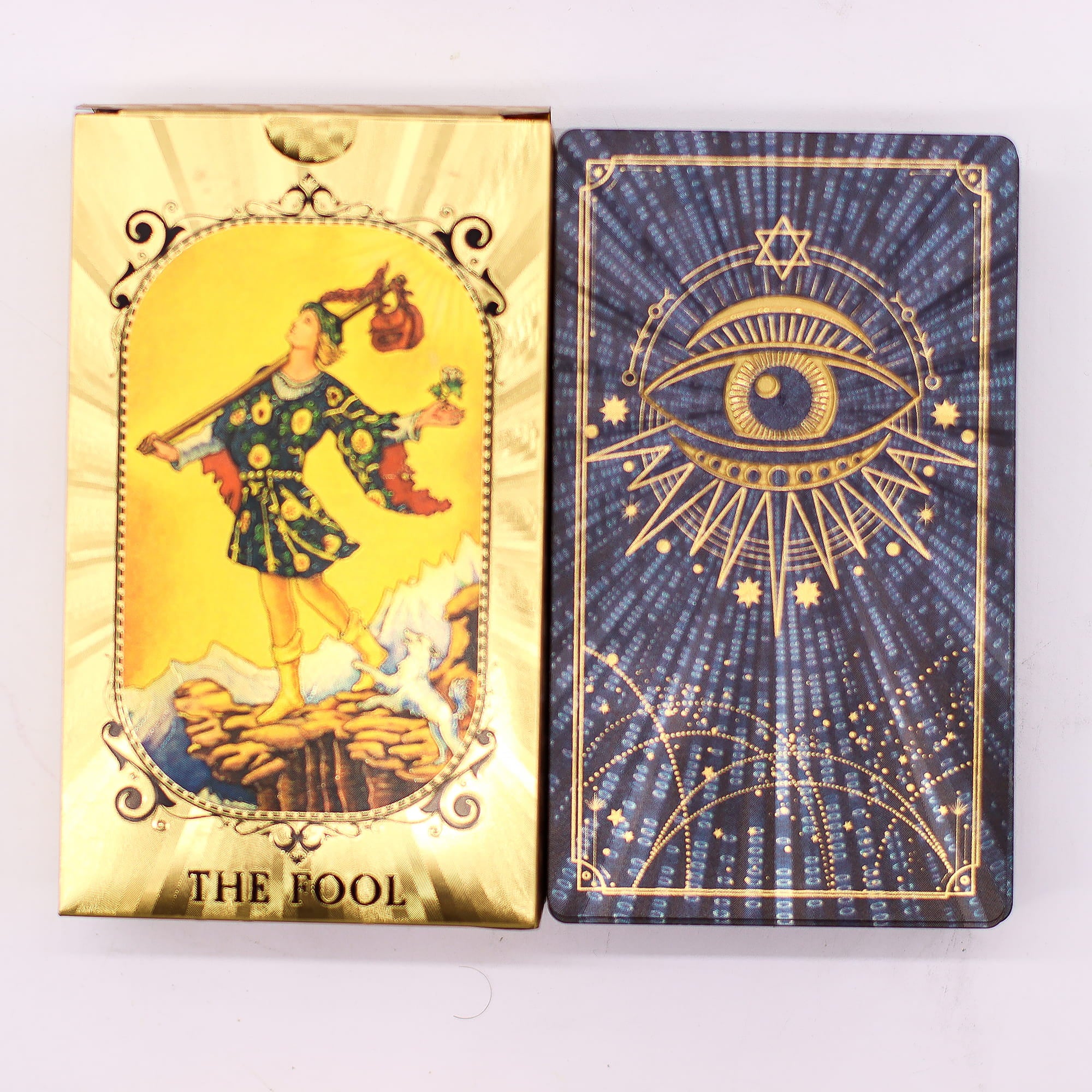 Gold Foil Tarot – zlatá krabička a zadní strana karty s motivem Vševidoucího oka na tmavém pozadí se zlatou fólií